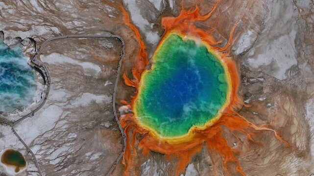 Grand Prismatic Springs Mid Geyser Basin boardwalk hike trail Wyoming Yellowstone National Park aerial drone birdseye view nature landscape cloudy morning colorful hot springs pools left motion