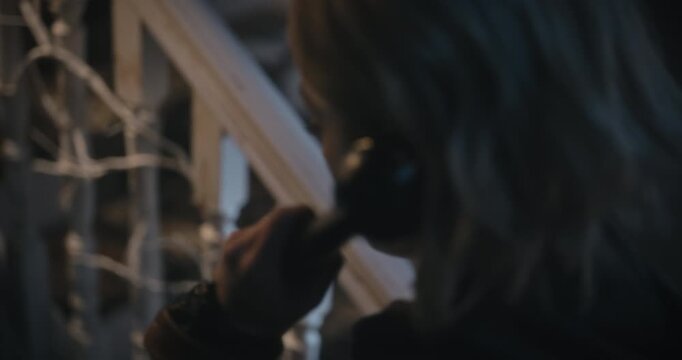 Handheld shot of anxious woman putting rotary phone receiver to her ear - steady cam closeup shot