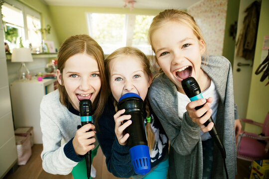 Three girls singing with microphone