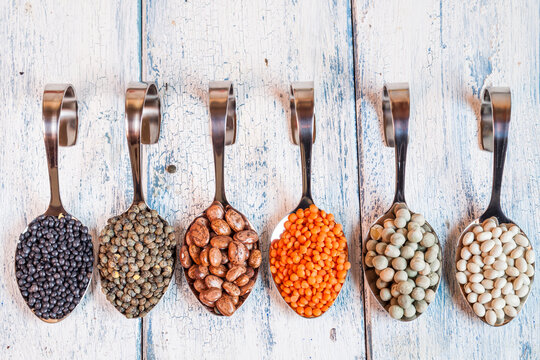 Row of spoons with different dried pulses