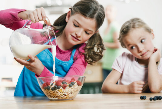 Germany, Cologne, Children preparing breakfast in kitchen