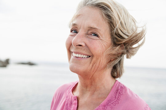 Spain, Senior woman smiling at Atlantic ocean