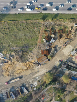 Aerial view of a construction site with rebar piles and heavy machinery next to a busy highway in Beylikduzu, Istanbul, Turkiye.