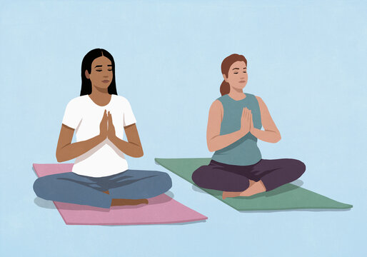 Serene multiracial young women meditating with hands clasped on yoga mats against blue background