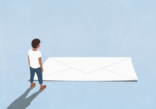 Man looking down at white envelope on blue background
