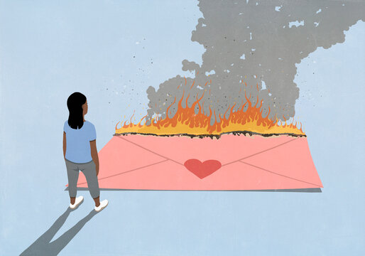 Woman looking down at large burning pink envelope with heart sticker