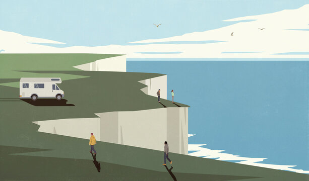 Tourists and camper trailer on cliff with scenic ocean view