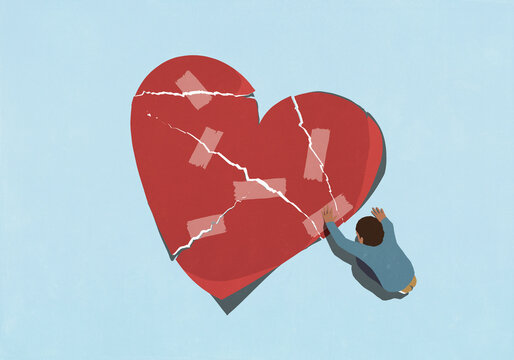 High angle view man repairing broken heart with adhesive tape