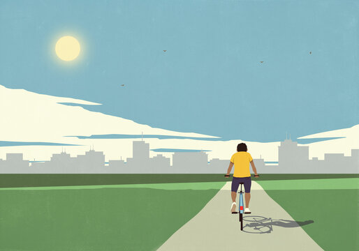 Man riding bicycle on path toward sunny summer city