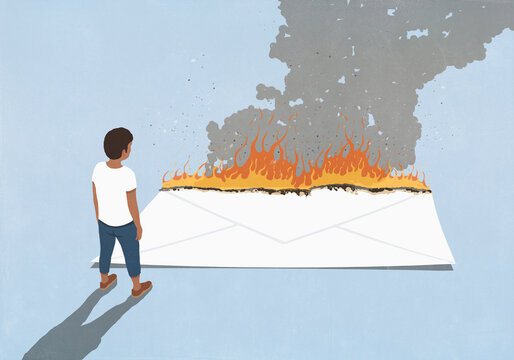 Man looking down at large white envelope burning on blue background