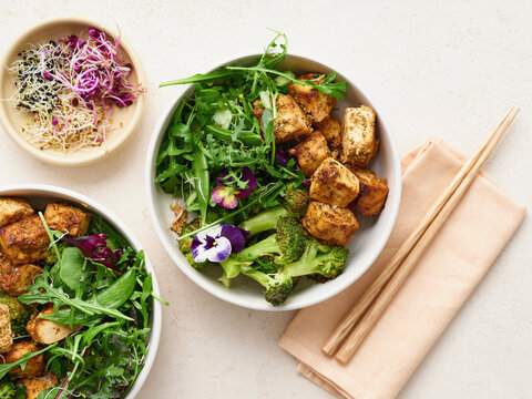 View from above of healthy, fresh tofu salad with broccoli and salad dressing
