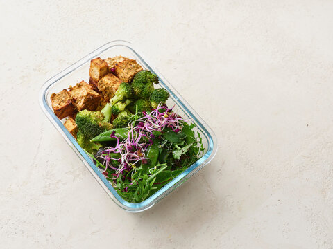 Healthy lunch in glass container - tofu, steamed broccoli, and lettuce