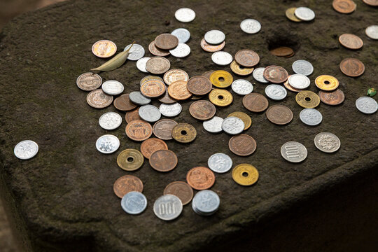 Variety of Japanese Yen coins on brown surface