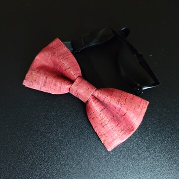 Pink bow tie with cork texture on a black background