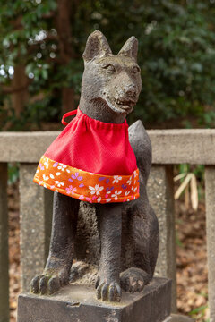 Small apron tied around neck of dog statue in park, Tokyo, Japan