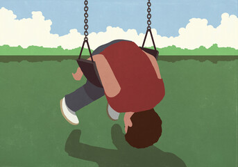 Boy folded over swing on playground