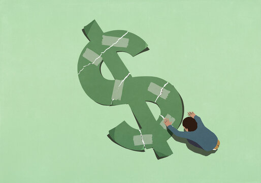 View from above of man attempting to repair ripped green dollar sign with adhesive tape