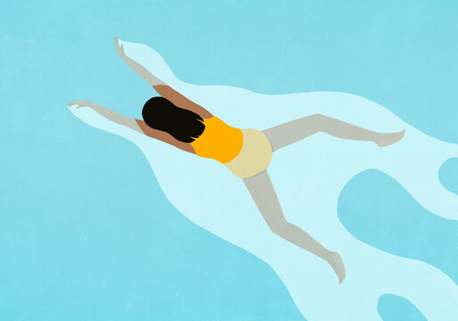 View from above of young woman in yellow bathing suit swimming in blue water