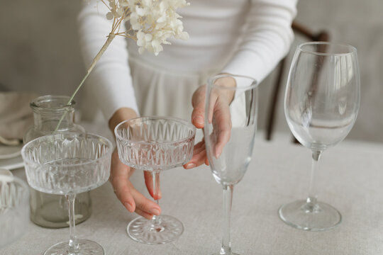 Close-up of a woman standing at a dining table setting the table for a dinner party