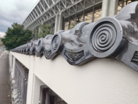 Traditional Japanese roof tiles with spiral pattern on a white wall