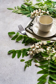Close-up of a place setting with fresh Acacia flowers on a concrete table