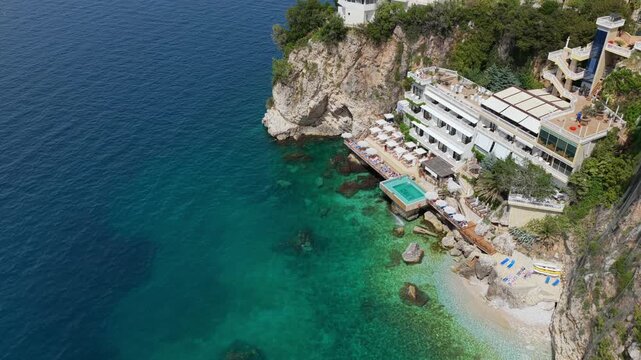 Aerial view of Vlora cliffside resort, secluded cove and turquoise Ionian sea