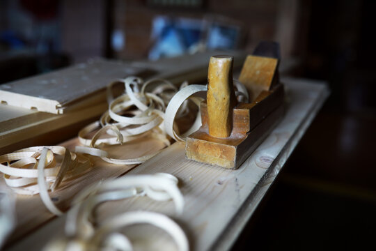 Plane jointer carpenter or joiner tool and wood shavings. Woodworking tools on wooden table. Carpentry workshop
