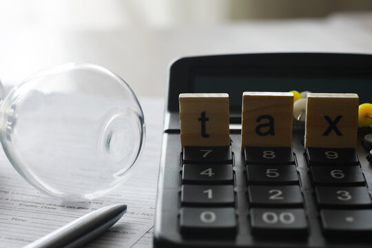Tax Calculation Concepts Featuring Wooden Blocks, Calculator, and Financial Paperwork