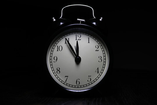 Classic Black Vintage Alarm Clock Showing Midnight on Dark Background