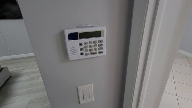 Person activating home alarm system using security control panel