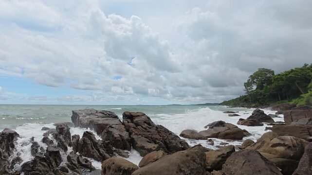 Waves crash against jagged coastal rocks.