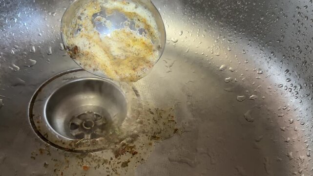 Hot foam carefully skimmed from boiling goat broth with large ladle and poured into sink while rich soup slowly cooks. steaming pot on stove.