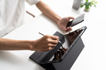 Using stylus on tablet for digital note taking and productivity technology concept. © Charlie's