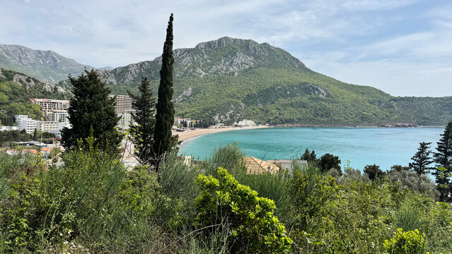 Canj Beach coastline with turquoise bay and forested limestone hills rising