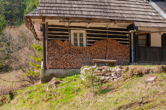 View of a traditional wooden log cabin at the Prasnica old charcoal burners' settlement with stacked firewood and a shingle roof Stare Hory, Banskobystricky kraj, Slovakia.