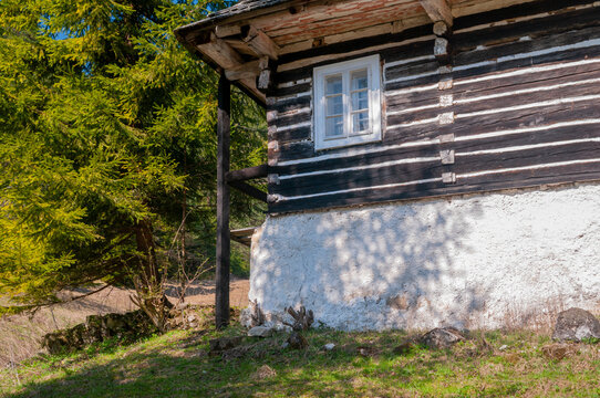 View of the traditional log cabin at Prasnica - old charcoal burners' settlement with its white stone base and wooden walls in Stare Hory, Banskobystricky kraj, Slovakia.