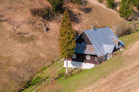 View of a traditional wooden cottage at the Prasnica - old charcoal burners' settlement on a grassy hillside Stare Hory, Banskobystricky kraj, Slovakia.