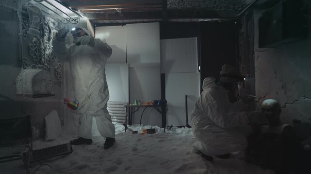 Medic in hazmat suit tends patient inside frostbitten cellar emergency care and stabilization with makeshift equipment, bandages and oxygen monitoring, decontamination procedures underway,