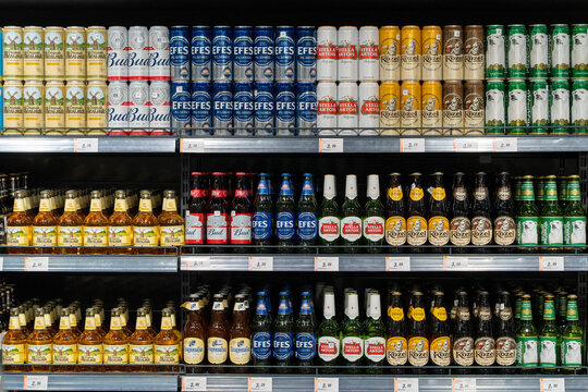 Beer Bottles And Cans On Supermarket Stand. Assortment of world beer brands on store shelves. Minsk, Belarus - March 30, 2026