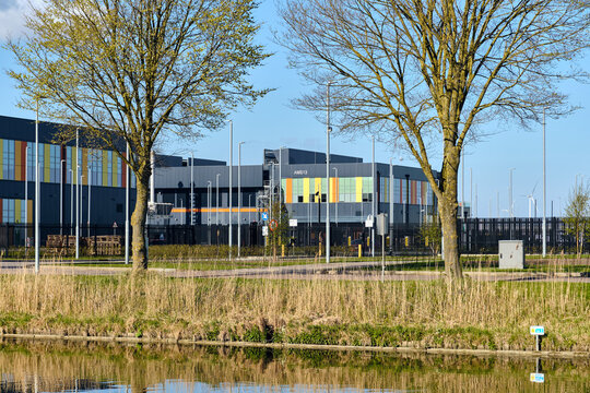 Middenmeer, Netherlands - 14 April 2026: View of Microsoft Datacenter Western Europe AMS Campus 13 Entrance gate with its modern facade, surrounding trees, and a canal in the foreground.