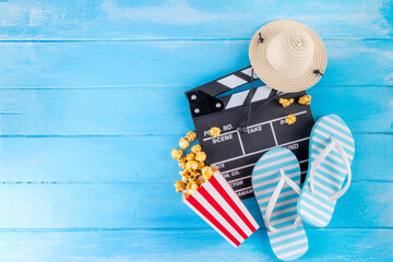 Summer holiday and vacation movie cinema marathon background Cinema clapper-board with sunglasses, seashells, starfish, popcorn buckets, vacation accessories, Cinema for the summer Movie Night party © ricka_kinamoto