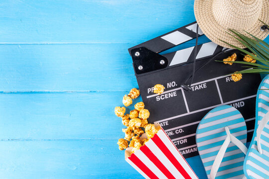 Summer holiday and vacation movie cinema marathon background Cinema clapper-board with sunglasses, seashells, starfish, popcorn buckets, vacation accessories, Cinema for the summer Movie Night party