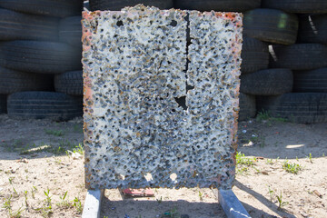 Paintball field with old tires and an iron plate target riddled with bullets © Таня Микитюк
