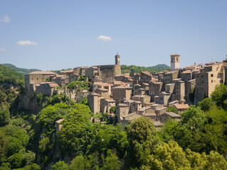 Fototapeta premium Scenic view of the dramatic hilltop town of Sorano surrounded by cliffs and greenery in Tuscany, Italy.