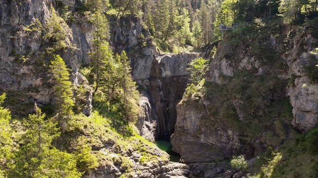 Majestic Waterfall Cascading into a Deep Gorge in the Lechtal Alps Surrounded by Lush Forest