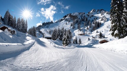 Obraz premium Snowy mountain landscape with ski trail and sunshine in clear sky