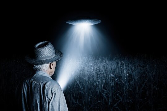 Elderly man in a hat encounters a mysterious UFO hovering over a cornfield at night.