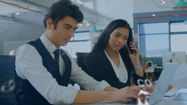 Woman calling and pointing docs while man typing, initiating laptop data entry with floating icons