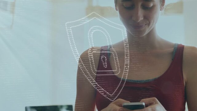 Woman showing phone and tapping screen in office, causing animated shield for data security