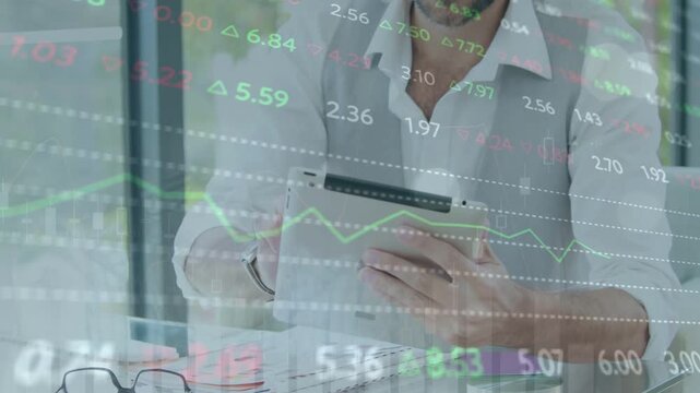 Man scanning tablet after market update, comparing charts with papers while tickers moving